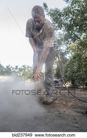 Caucasian man cleaning part with air hose View Large Photo Image Stock Photo - Caucasian man cleaning part with air hose. Fotosearch