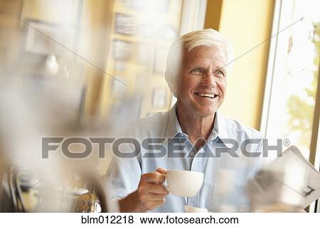 Caucasian man drinking coffee in restaurant View Large Photo Image Stock Photo - Caucasian man drinking coffee in restaurant. Fotosearch
