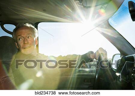 Stock Photo - Caucasian man driving car looking back. Fotosearch