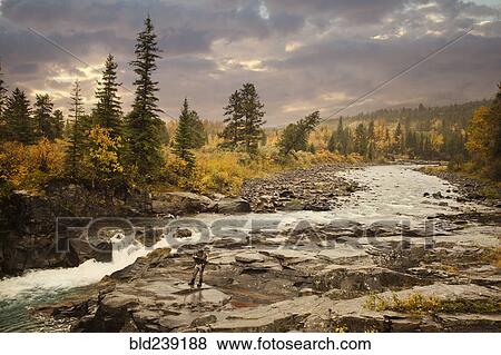 Stock Photo - Caucasian man fishing at river. Fotosearch