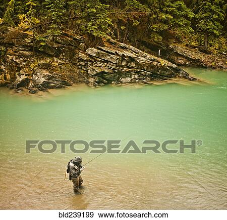 Stock Photo - Caucasian man fishing in river. Fotosearch