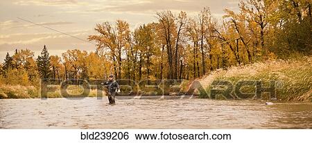 Stock Photograph - Caucasian man fishing in river. Fotosearch