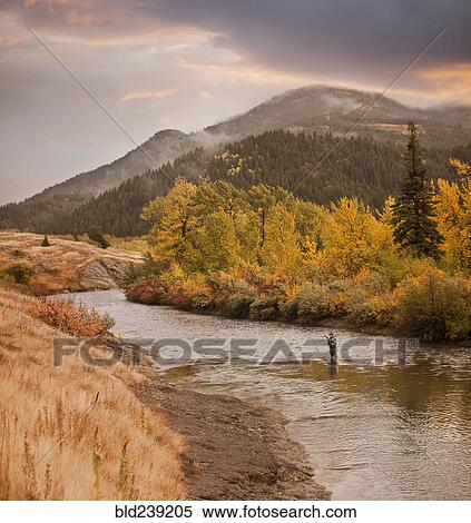 Stock Photography - Caucasian man fishing in river. Fotosearch