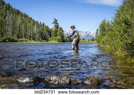 Caucasian man fly fishing in river View Large Photo Image Stock Image - Caucasian man fly fishing in river. Fotosearch