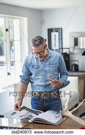 Stock Image - Caucasian man holding staircase reading book. Fotosearch