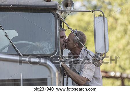 Stock Image - Caucasian man kissing truck driver. Fotosearch