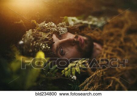 Stock Image - Caucasian man laying in grass. Fotosearch