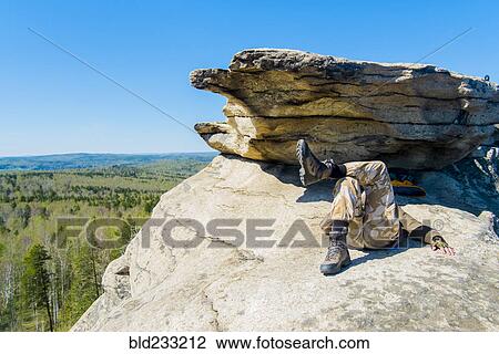 Caucasian man laying on mountain rock under blue sky View Large Photo Image Stock Image - Caucasian man laying on mountain rock under blue sky. Fotosearch