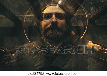 Stock Image - Caucasian man laying under glass table. Fotosearch