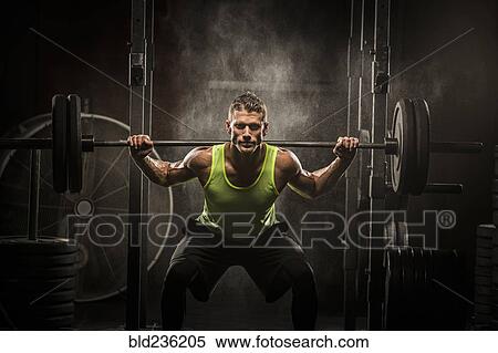 Stock Photography - Caucasian man lifting barbell in gymnasium. Fotosearch