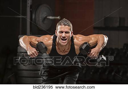 Caucasian man lifting dumbbells in gymnasium View Large Photo Image Stock Photography - Caucasian man lifting dumbbells in gymnasium. Fotosearch