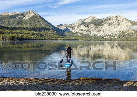 Caucasian man paddleboarding on mountain lake View Large Photo Image Stock Image - Caucasian man paddleboarding on mountain lake. Fotosearch