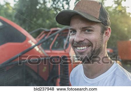 Caucasian man posing near tractor View Large Photo Image Stock Photo - Caucasian man posing near tractor. Fotosearch