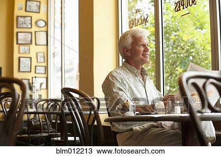 Caucasian man reading newspaper in restaurant View Large Photo Image Stock Image - Caucasian man reading newspaper in restaurant. Fotosearch