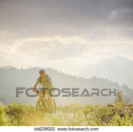 Stock Image - Caucasian man riding mountain bike. Fotosearch