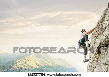 Picture - Caucasian man rock climbing. Fotosearch