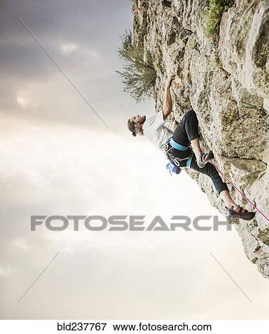 Stock Photo - Caucasian man rock climbing. Fotosearch