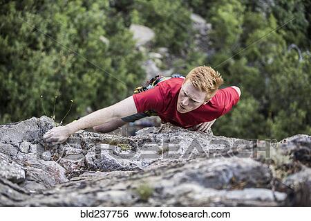 Stock Photograph - Caucasian man rock climbing. Fotosearch