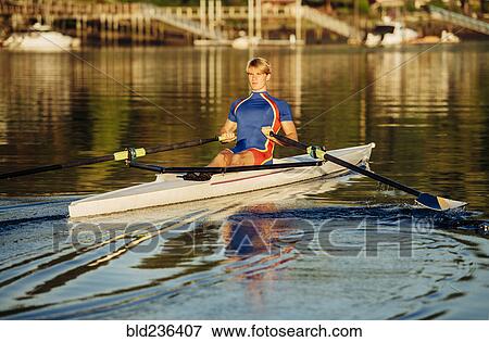Stock Photo - Caucasian man rowing on river. Fotosearch