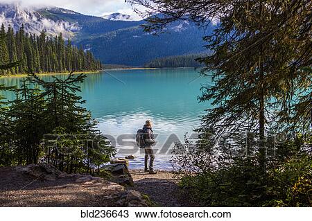 Caucasian man standing at mountain lake View Large Photo Image Stock Image - Caucasian man standing at mountain lake. Fotosearch