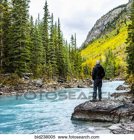 Caucasian man standing on rock near mountain river View Large Photo Image Stock Photography - Caucasian man standing on rock near mountain river. Fotosearch