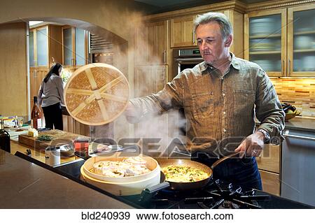 Caucasian man steaming food on stove View Large Photo Image Stock Photo - Caucasian man steaming food on stove. Fotosearch