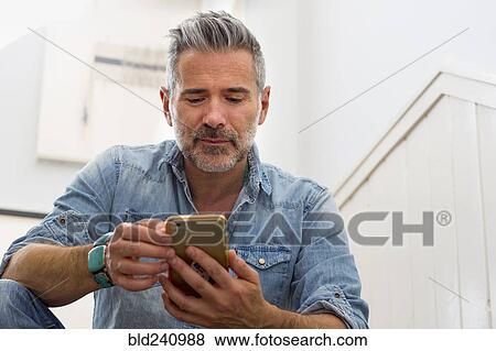 Caucasian man texting on cell phone View Large Photo Image Stock Photo - Caucasian man texting on cell phone. Fotosearch