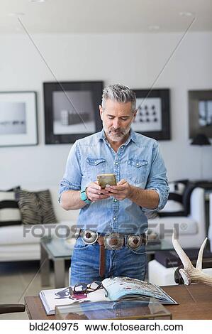 Stock Photography - Caucasian man texting on cell phone. Fotosearch