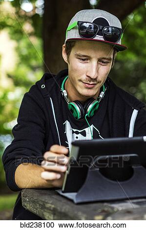 Stock Image - Caucasian man using digital tablet outdoors. Fotosearch