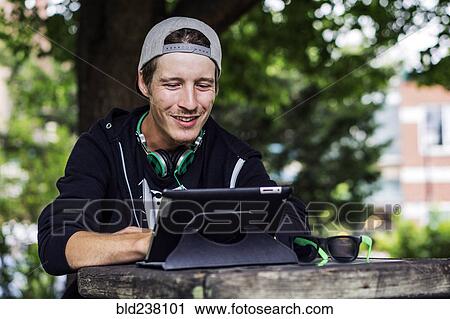 Caucasian man using digital tablet outdoors View Large Photo Image Stock Image - Caucasian man using digital tablet outdoors. Fotosearch
