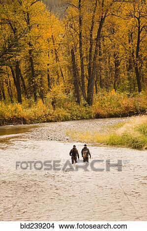 Picture - Caucasian men fishing in river. Fotosearch
