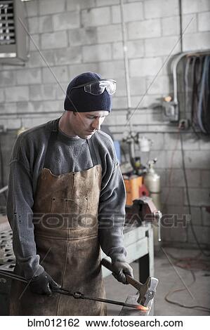 Caucasian metal worker pounding metal in workshop View Large Photo Image Stock Image - Caucasian metal worker pounding metal in workshop. Fotosearch