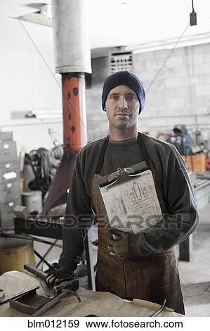 Caucasian metal worker standing in workshop View Large Photo Image Stock Photo - Caucasian metal worker standing in workshop. Fotosearch