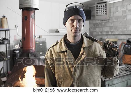 Caucasian metal worker standing in workshop View Large Photo Image Stock Photograph - Caucasian metal worker standing in workshop. Fotosearch