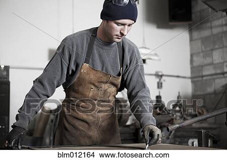 Picture - Caucasian metal worker working in workshop. Fotosearch