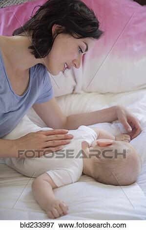 Caucasian mother and baby son laying on bed View Large Photo Image Stock Photo - Caucasian mother and baby son laying on bed. Fotosearch