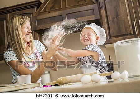 Caucasian mother and daughter having food fight with flour View Large Photo Image Stock Photograph - Caucasian mother and daughter having food fight with flour. Fotosearch