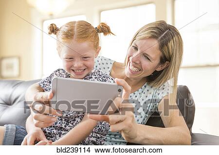 Caucasian mother and daughter posing for cell phone selfie View Large Photo Image Picture - Caucasian mother and daughter posing for cell phone selfie. Fotosearch