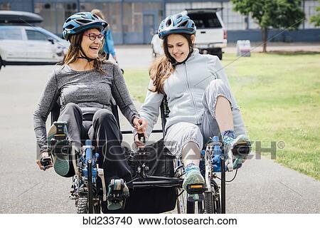 Stock Image - Caucasian mother and daughter riding tandem bicycle. Fotosearch