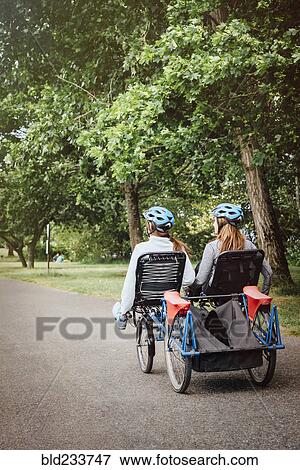 Stock Photo - Caucasian mother and daughter riding tandem bicycle. Fotosearch