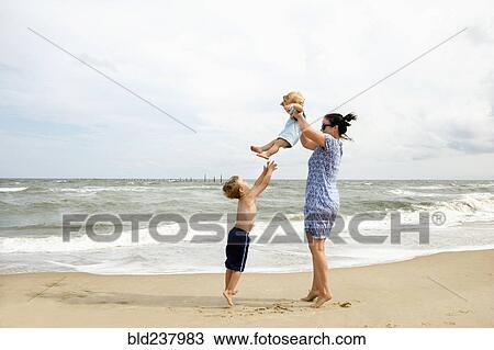 Caucasian mother and sons playing at beach View Large Photo Image Stock Image - Caucasian mother and sons playing at beach. Fotosearch