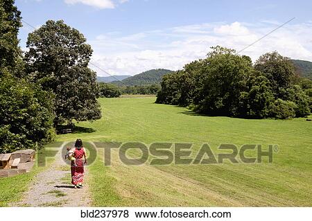 Stock Photo - Caucasian mother carrying son in park. Fotosearch