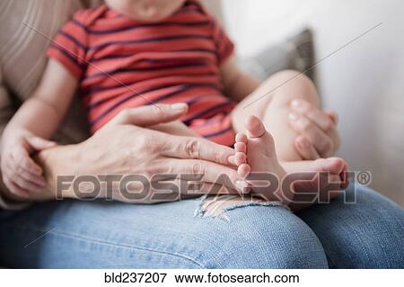 Stock Photo - Caucasian mother holding baby son in lap. Fotosearch