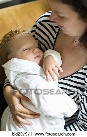 Stock Image - Caucasian mother holding baby son. Fotosearch