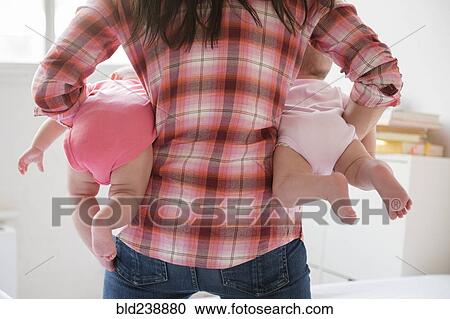 Caucasian mother holding twin baby daughters View Large Photo Image Stock Image - Caucasian mother holding twin baby daughters. Fotosearch