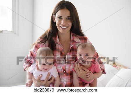 Caucasian mother holding twin baby daughters View Large Photo Image Stock Photo - Caucasian mother holding twin baby daughters. Fotosearch