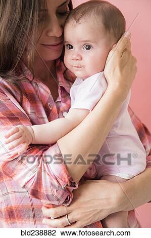 Caucasian mother hugging baby daughter View Large Photo Image Stock Image - Caucasian mother hugging baby daughter. Fotosearch