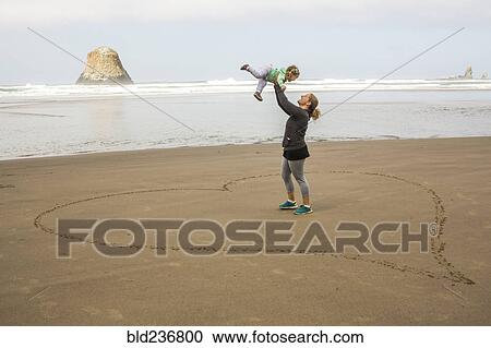 Caucasian mother lifting daughter in heart-shape on beach View Large Photo Image Stock Image - Caucasian mother lifting daughter in heart-shape on beach. Fotosearch