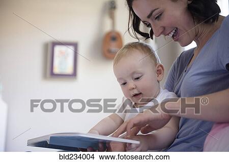 Caucasian mother reading book to baby son View Large Photo Image Picture - Caucasian mother reading book to baby son. Fotosearch