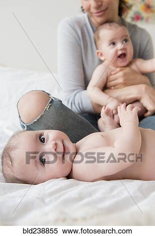 Caucasian mother with twin baby daughters on bed View Large Photo Image Stock Photography - Caucasian mother with twin baby daughters on bed. Fotosearch